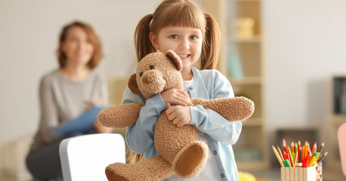 a child holding her teddy bear
