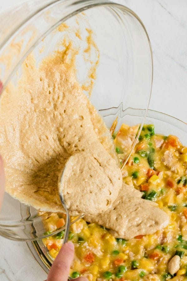 topping being poured on a pot pie