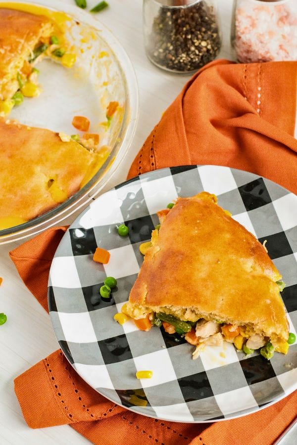 turkey pot pie on a plate next to the pan of pot pie