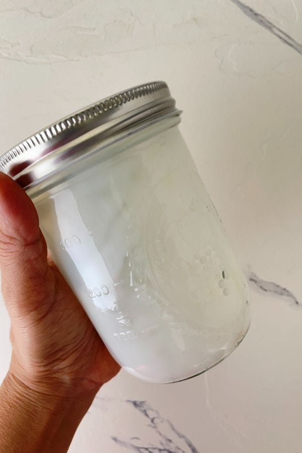 shaking milk for latte in a mason jar
