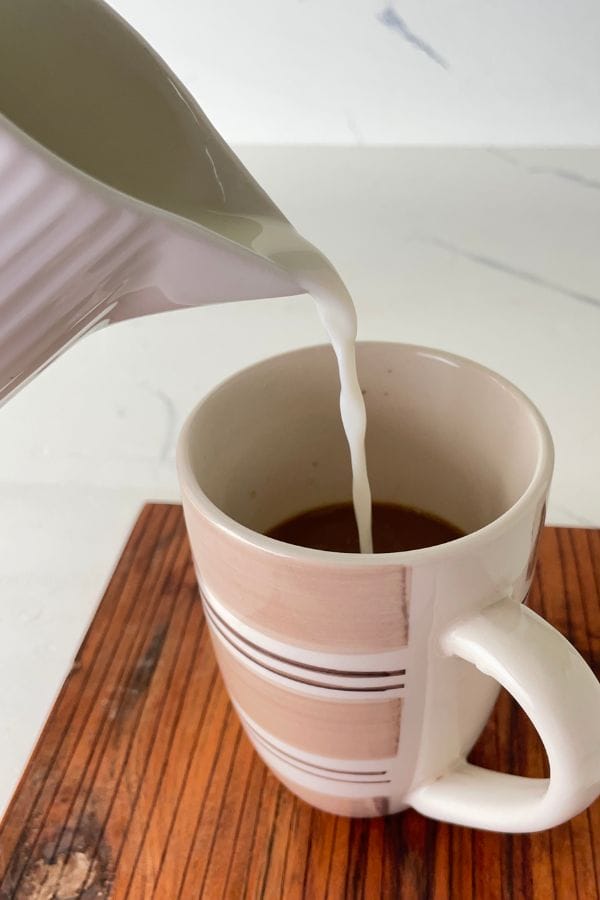 adding milk to latte cup