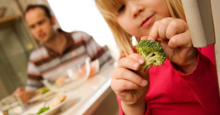 a child picking at broccoli