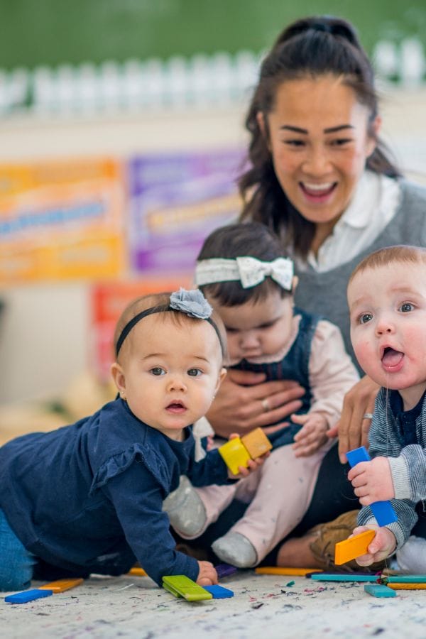 daycare provider smiling with kids