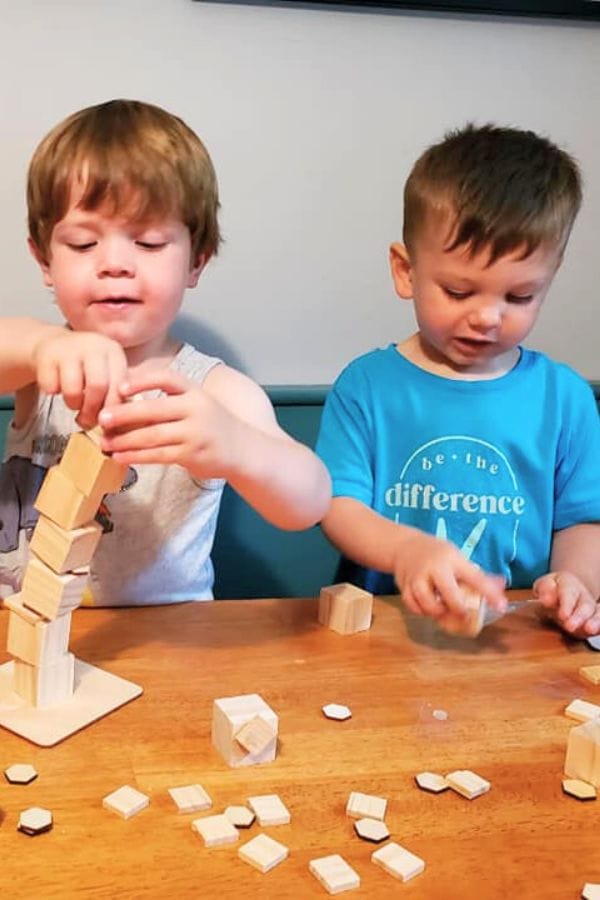 kids building with cubes and wooden shapes and glue dots making sculptures