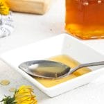 dandelion syrup in a bowl with a spoon