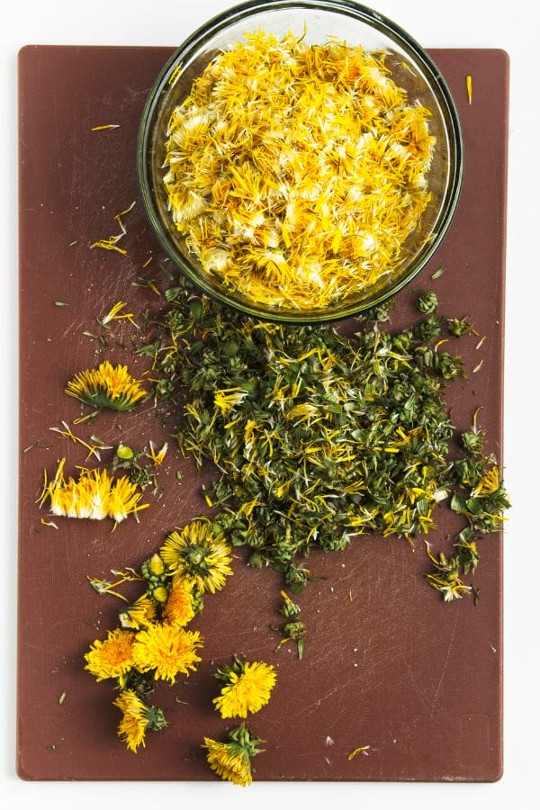 dandelion petals ripped off of flowers on a board and in a bowl