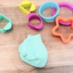 cloud dough and cookie cutters on a board