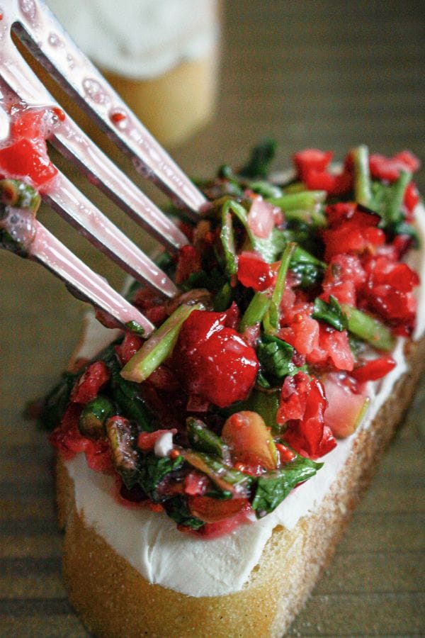 a piece of bread topped with cranberry salsa and a fork