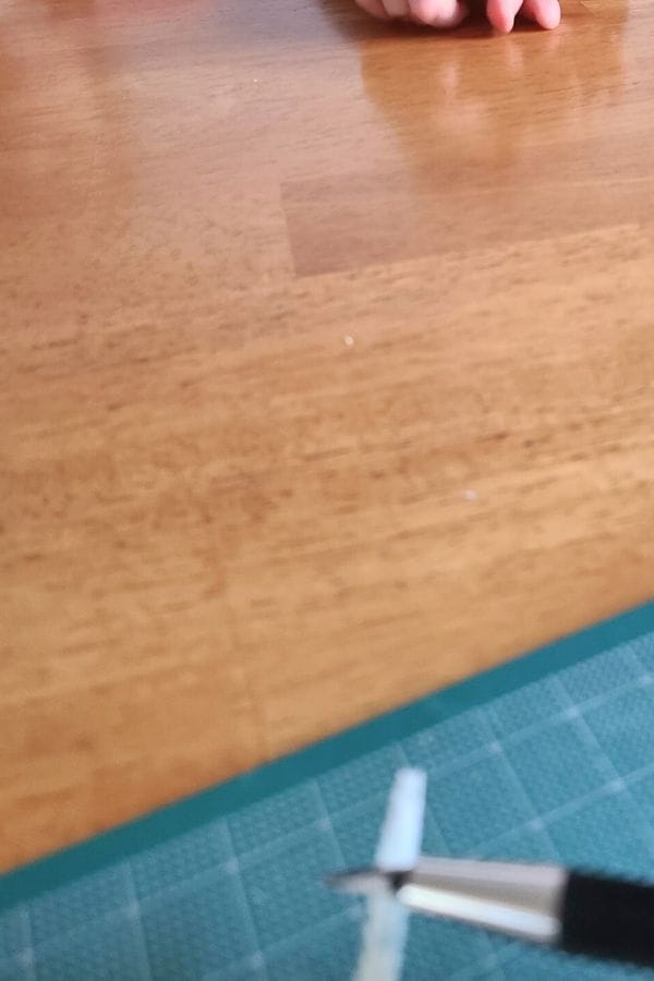 the end of a feather being cut with an exacto knife