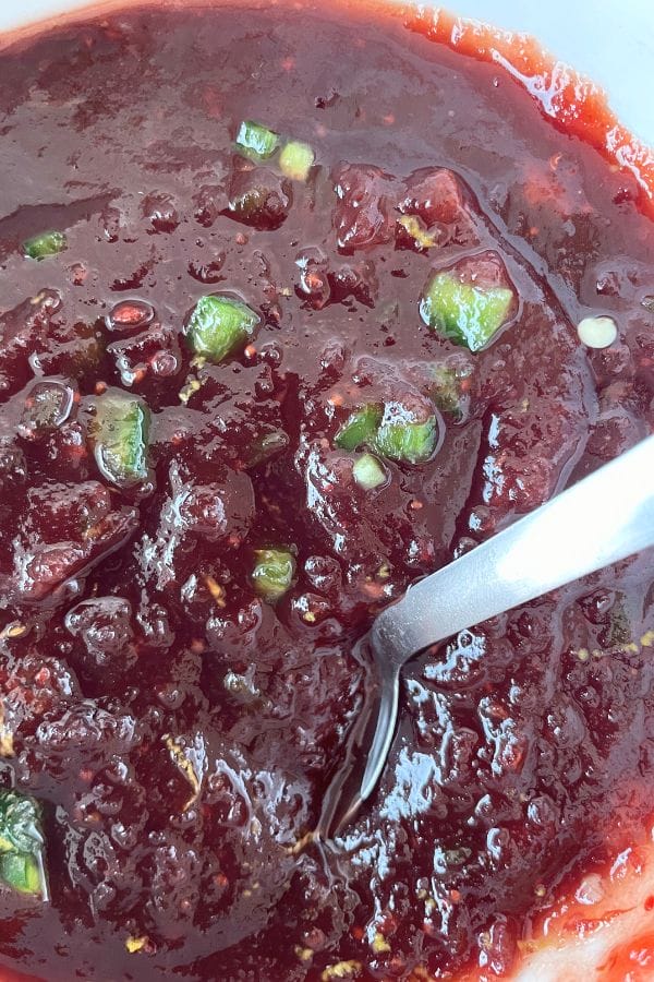 mixing jalapeno peppers into cranberry sauce