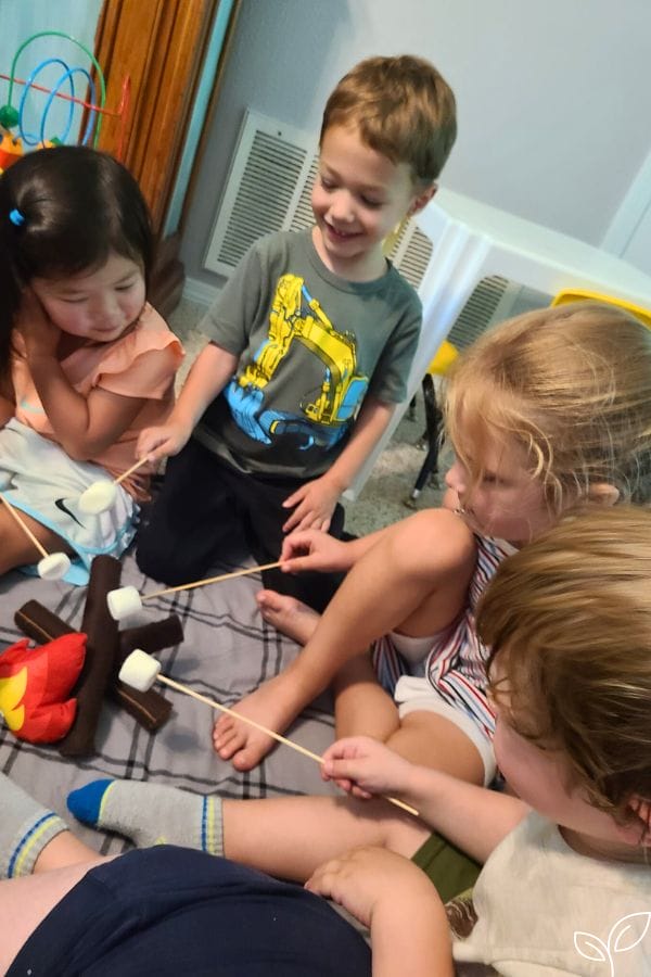kids pretending to roast marshmallows on a pretend camp fire
