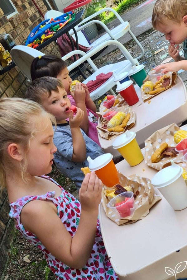 Kids eating a huckleberry finn picnic