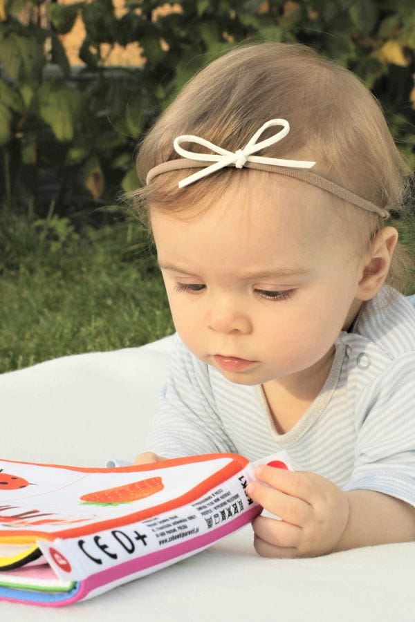 Baby looking at a book in the garden