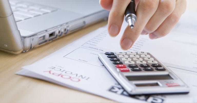 an invoice and a calculator working on accounting