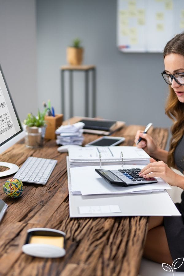 a woman working on her accounting at a desk