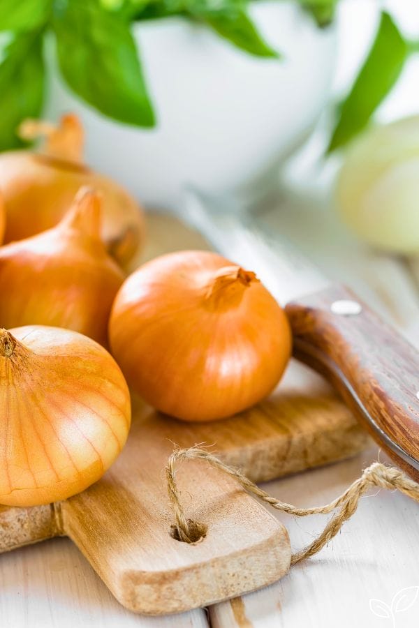 onions and a knife on a cutting board