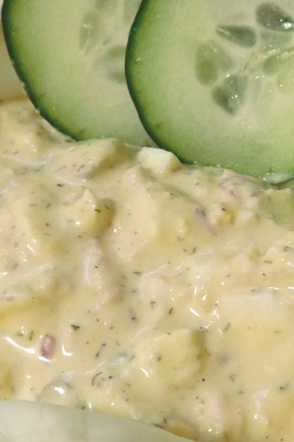 close up of tuna salad with cucumbers on top