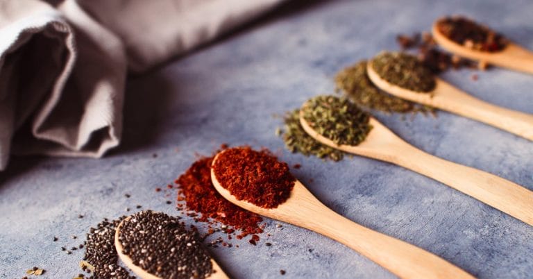 spices lined up on a counter in spoons