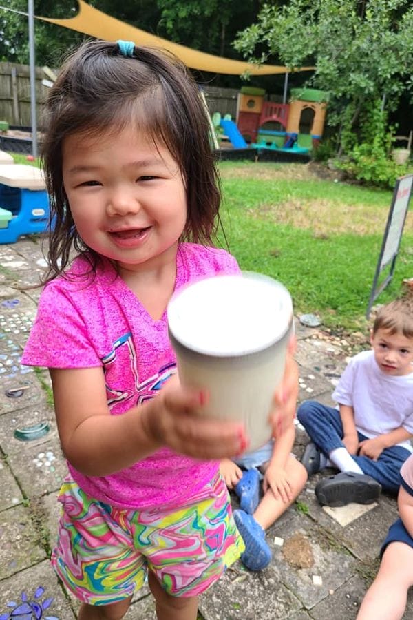 a child shaking a jar of cream to make butter like anne of green gables