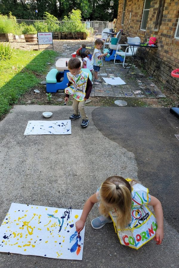 Kids making Jackson Pollock style splash paint on the patio