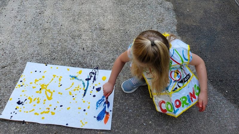 a child splatter painting on the patio