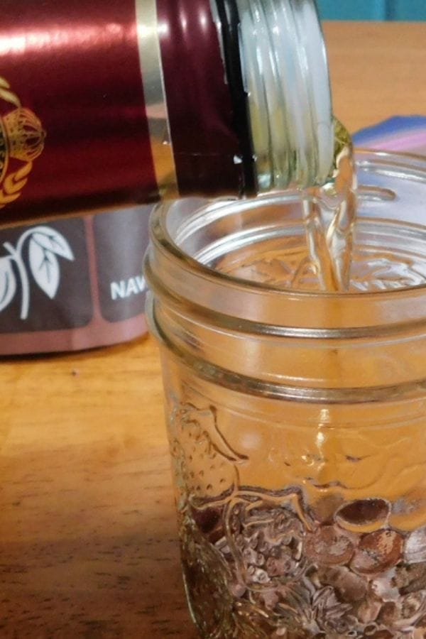 alcohol pouring into a mason jar to make extract