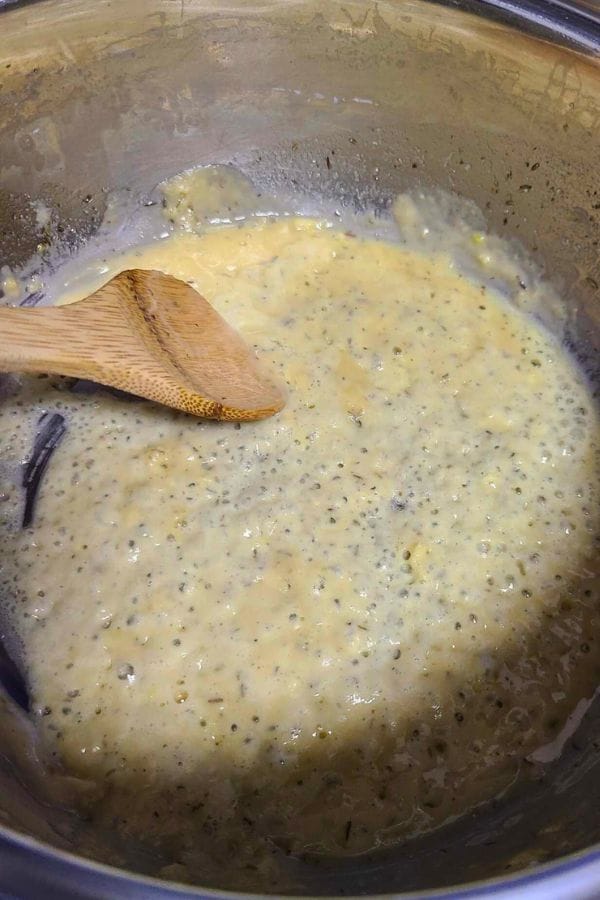 A pot flour and butter cooking into a roux. Being stirred by a wooden spoon evokes the coziness of a broccoli tuna casserole. The mixture's thick consistency and lightly browned look show it's almost ready for milk. 