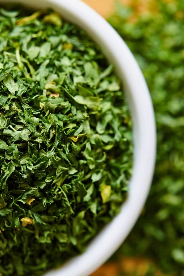 Close-up of a bowl filled with dried parsley flakes