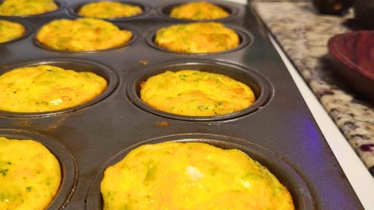 Broccoli Cheese Egg Cups with green vegetables baked in a muffin tray on a granite countertop.