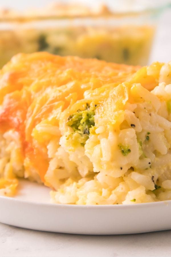 A close-up of a serving of cheesy broccoli casserole, perfect for those looking for broccoli recipes for kids, presented on a white plate.
