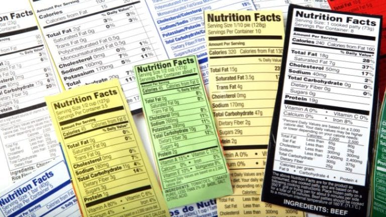 A variety of colorful CN Labels for CACFP are arranged overlapping each other, displaying nutritional information for different food products.