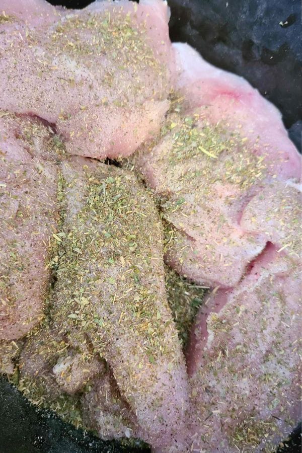 Raw chicken pieces seasoned with herbs and spices, ready to be transformed into a delicious Green Bean Chicken Casserole.