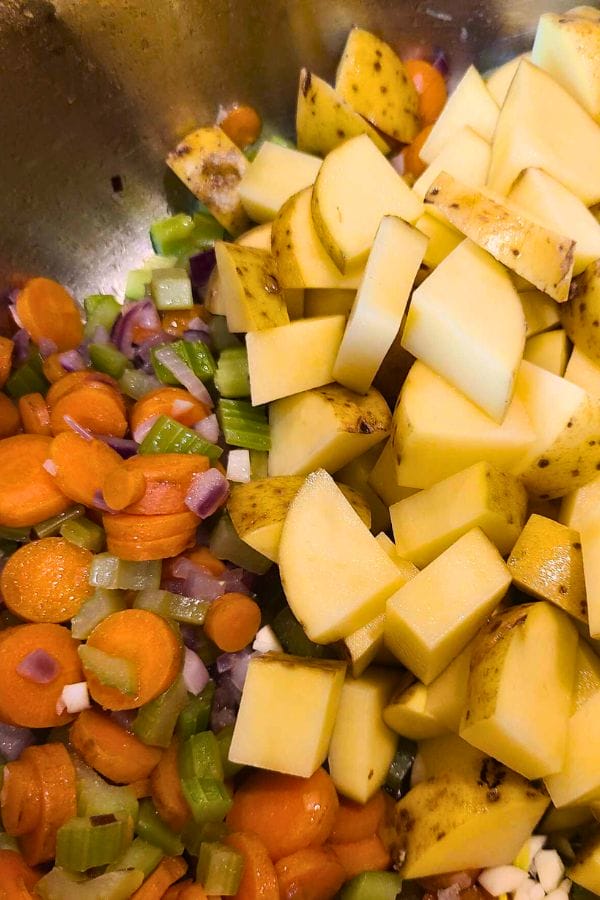 Chopped potatoes, carrots, celery, and onions await their transformation into a hearty leftover pork tenderloin soup. Perfect for cozy evenings.