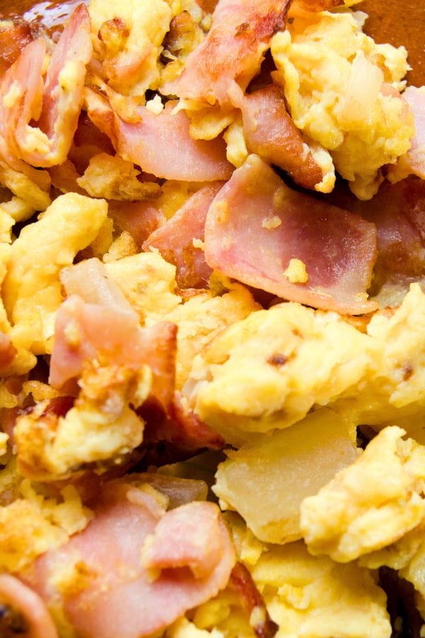 Close-up of scrambled eggs mixed with slices of cooked bacon—perfect for quick dinner ideas with lunch meat.