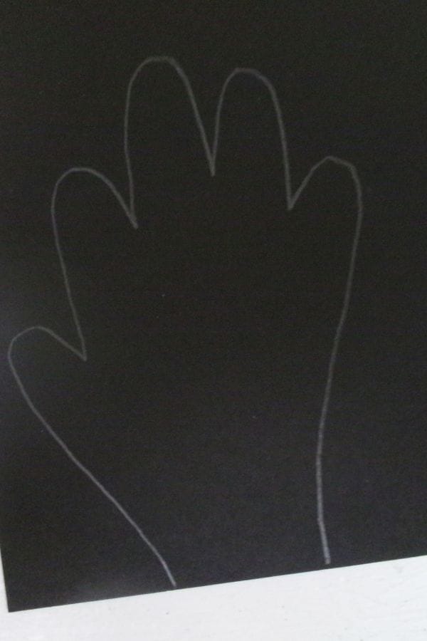 A simple white outline of a left hand traced on a black background, resembling a Handprint Bat in its shape and spread fingers.
