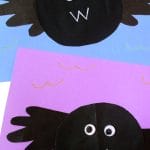 Two Handprint Bat crafts feature black circular bodies, handprint wings, googly eyes, and "W" shaped mouths, showcased on blue and purple backgrounds.