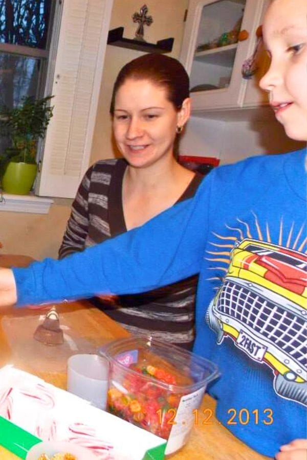A woman and child sit at a kitchen table with candy and peppermint sticks, perhaps preparing for Lesson Plans on Gingerbread. The date on the photo reads 12-12-2013.