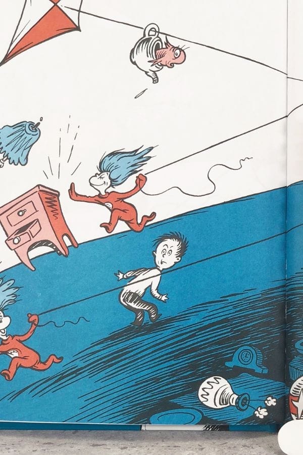 Illustration shows cartoon characters running and objects flying—including a kite, a fishbowl, a cat, and furniture—against a blue and white background, perfect for inspiring creative Lesson Plans on The Cat in the Hat.