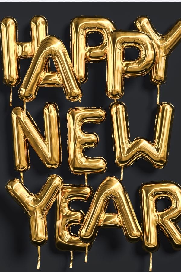 Gold foil balloons spell out "HAPPY NEW YEAR" against a dark background, creating a festive focal point perfect for any New Year’s Eve Kid’s Party.