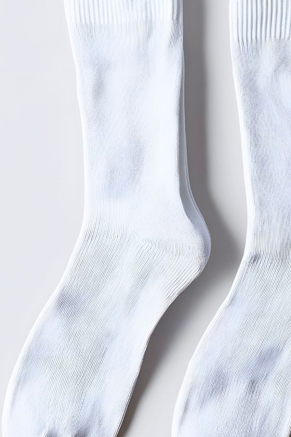 A pair of plain white ribbed socks laid flat on a white surface, perfect to use for an Easy Snowman Craft.